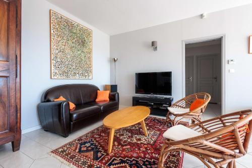 un salon avec un canapé en cuir et une table dans l'établissement Villa Rochefort - Welkeys, à Rochefort-du-Gard