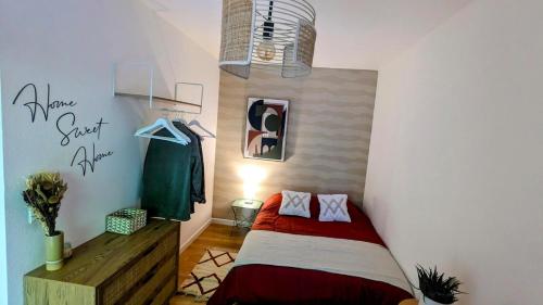 - une petite chambre avec un lit rouge dans l'établissement T1bis meublé cozy avec jardin et parking privé, à Toulouse