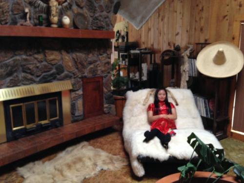 a girl sitting on a bean bag chair in a room with a fireplace at HOUSE OF THE FUTURE MANSION MASTER BEDROOM, In W LANSING in Lansing