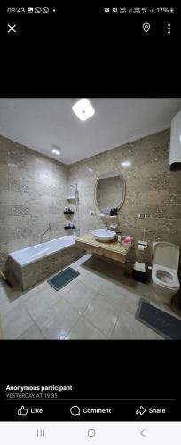 a bathroom with a tub and a sink and a toilet at كمبوند المقصد in Kafr ash Sharā‘inah