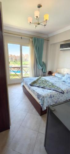 a bedroom with a bed and a large window at Aqua View Chalet at Piacera Resort-Ain Sokhna in Ain Sokhna