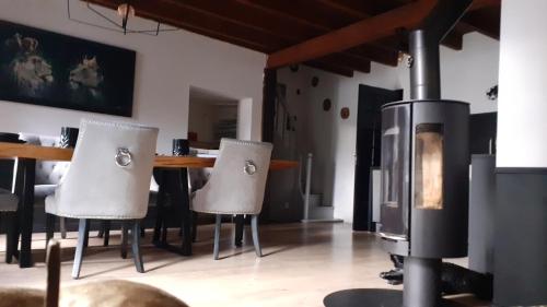 - un salon avec un poêle à bois et une table dans l'établissement Gîte de Brocéliande Sauna & Spa, à Saint-Malon-sur-Mel