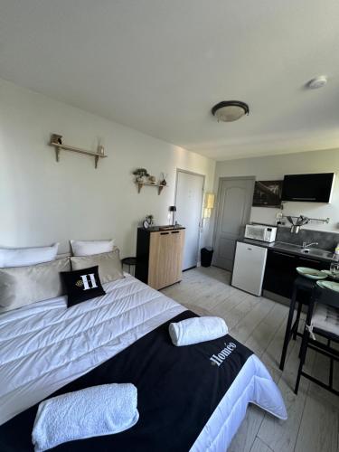 une chambre avec un grand lit et une cuisine dans l'établissement Le Cosy De La Gare 3, à Nazelles-Négron