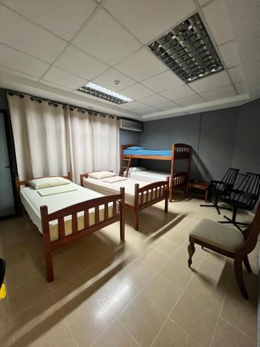 a room with two beds and a table at Panama Hat Hostel in Panama City