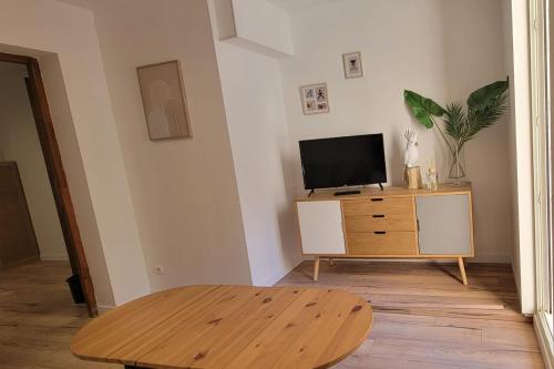 - un salon avec une télévision et une table en bois dans l'établissement Apartment of 32 m2 2 min from the beach Fréjus, à Fréjus