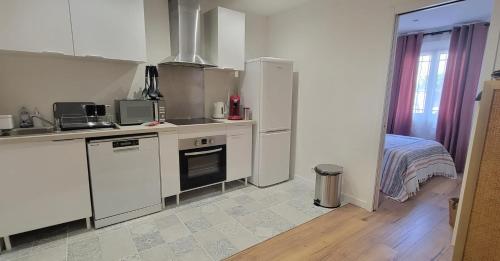 - une cuisine avec des appareils blancs et un lit dans une chambre dans l'établissement Apartment of 32 m2 2 min from the beach Fréjus, à Fréjus