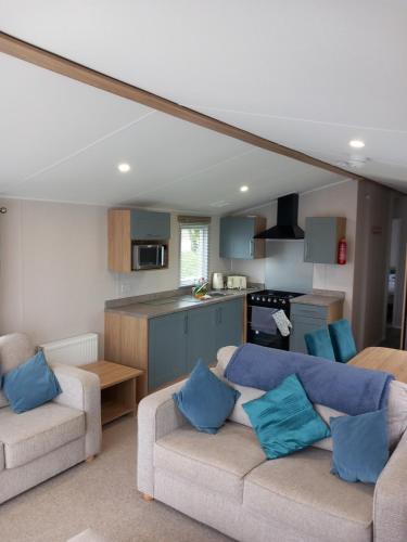 a living room with two couches and a kitchen at Walnut 65 - Porthcawl in Newton