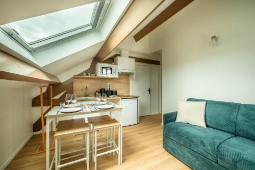a kitchen and living room with a blue couch at LE MACHU PICCHU - Self Checkin Automatique - Netflix - 15 Min de Giverny in Bonnières-sur-Seine