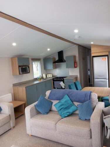 a living room with a couch and a kitchen at Walnut 65 - Porthcawl in Newton
