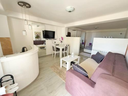 a living room with a purple couch and a table at Apartmani Avanti Becici in Becici