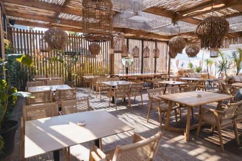 un ristorante con tavoli e sedie in legno e piante di Nikolas House a Vlorë