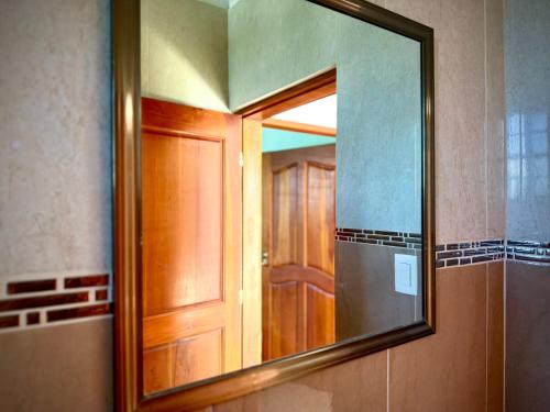 a mirror in a bathroom with a wooden door at Apartment in Center of Corozal in Corozal