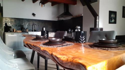 - une table en bois avec des bols dans la cuisine dans l'établissement Gîte de Brocéliande Sauna & Spa, à Saint-Malon-sur-Mel