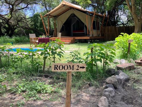 a sign in front of a tent in a yard at Keremasi Camp Lake Natron in Mtowabaga