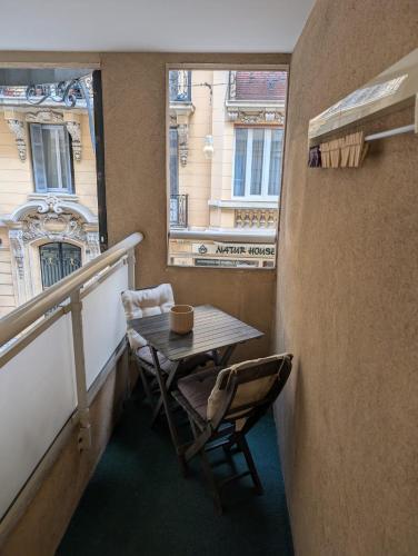 une table et des chaises sur un balcon avec une fenêtre dans l'établissement Studio Beausoleil Central MC, à Beausoleil