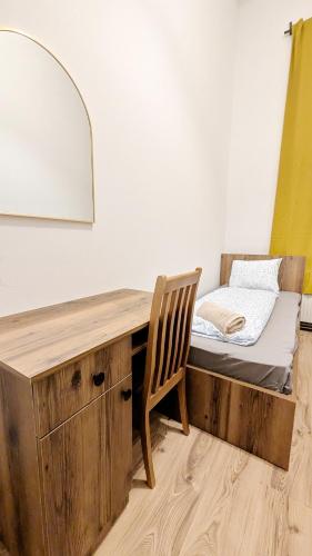 a bed with a desk and a chair in a room at Spacious Rooms - 15 Min from Airport & City Center, 5 Min from Vienna Main-Bus Station EZ1 in Vienna