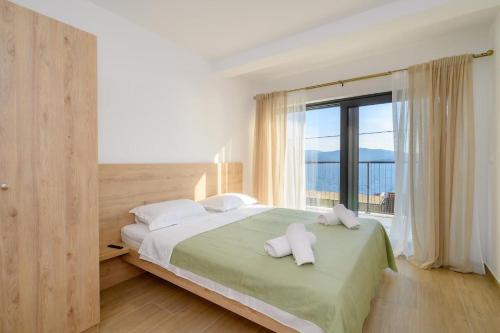 a bedroom with a bed and a large window at Apartments Sunset Komarna in Komarna