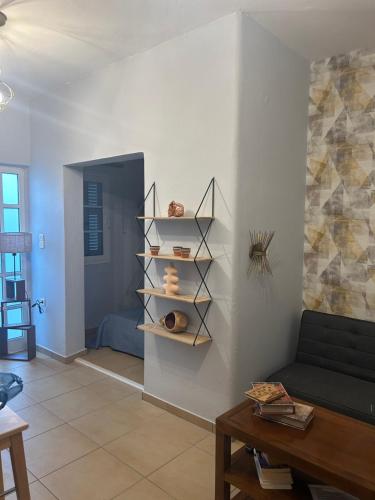 a living room with a couch and shelves on the wall at Apartment view sea artemida in Mesochórion