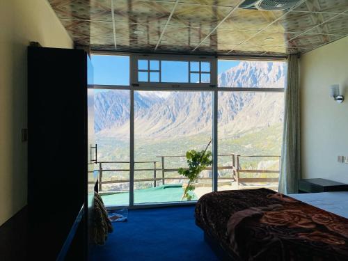 a bedroom with a large window with a view of a mountain at Venus Mountain Resort, Hunza in Hunza