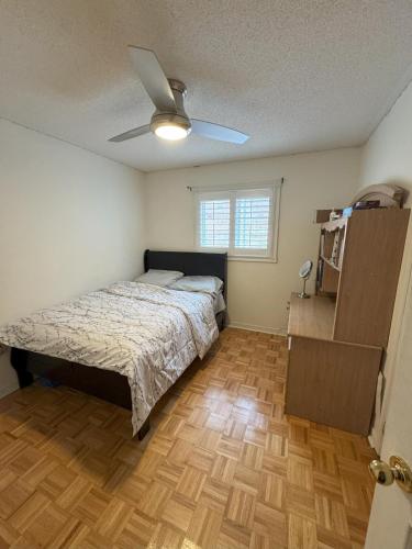 a bedroom with a bed and a ceiling fan at Pearson Gateway Comfort Home in Mississauga