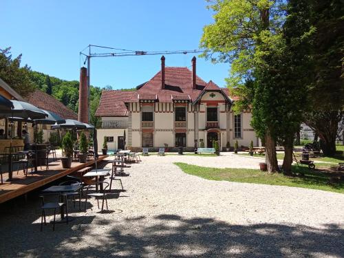 un grand bâtiment avec des tables et des chaises devant dans l'établissement Best Price #A 