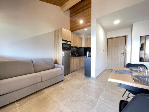 un salon avec un canapé et une cuisine dans l'établissement Charmant appartement neuf avec terrasse au Cernix - FR-1-505-229, à Crest-Voland