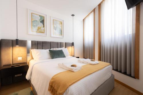 a bedroom with a large bed with towels on it at Coruja’s House AL OPO in Porto