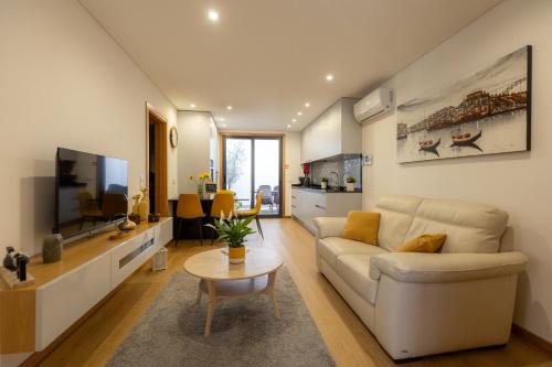 a living room with a couch and a tv at Coruja’s House AL OPO in Porto