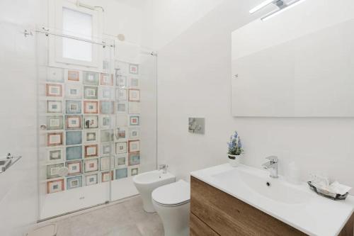 a white bathroom with a toilet and a sink at Lazzara 19 in Marsala