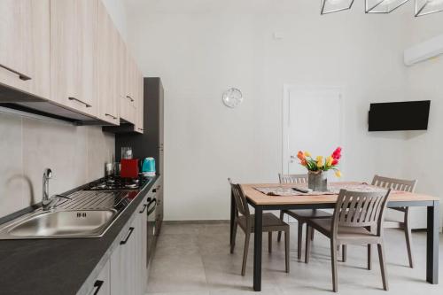 a kitchen with a table with chairs and a sink at Lazzara 19 in Marsala