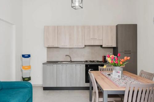a kitchen with a table with flowers on it at Lazzara 19 in Marsala