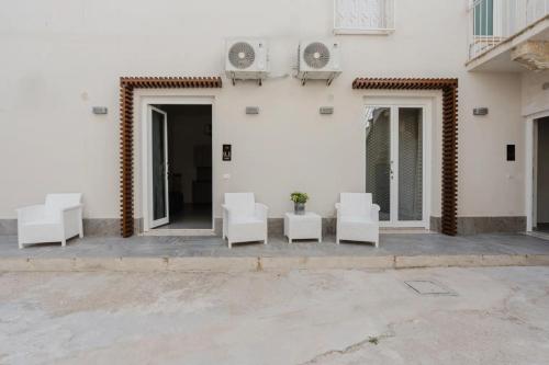 a group of white chairs sitting outside of a building at Lazzara 19 in Marsala