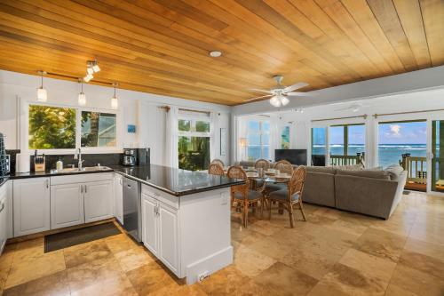 a kitchen and dining room with a couch and a table at Kauai Aliomanu Sunrise Hale by Coldwell Banker Island Vacations in Anahola