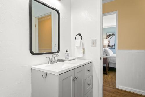 Un baño blanco con lavabo y espejo. en Kauai Alii Kai 2-102 by Coldwell Banker Island Vacations, en Princeville