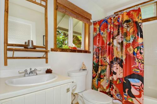 a bathroom with a toilet and a sink and a shower curtain at Kauai Hale Iki by Coldwell Banker Island Vacations in Kapaa