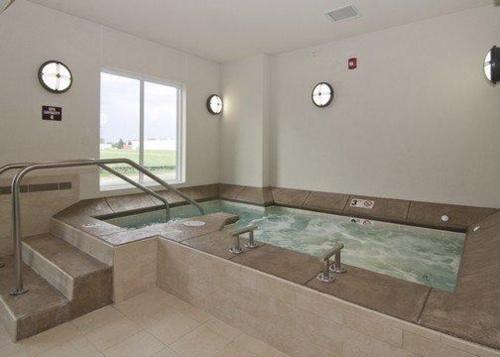 uma grande banheira de hidromassagem num quarto com relógios em Sleep Inn & Suites Marshall em Marshall