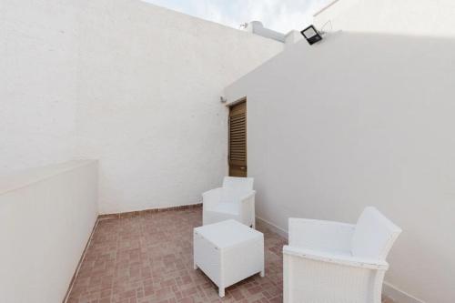 an empty room with white chairs and a table at Lazzara 19 in Marsala