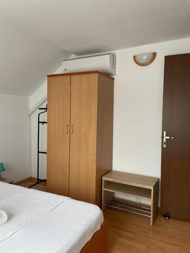 a bedroom with a bed and a wooden cabinet at Casa Melania in Eşelniţa