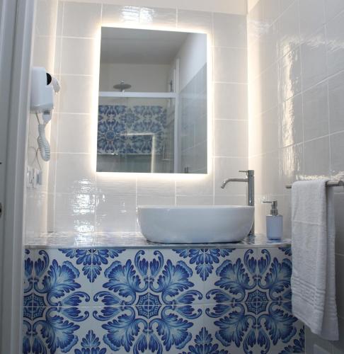 a blue and white bathroom with a sink and a mirror at The twins Rooms in Marettimo 2 in Marettimo