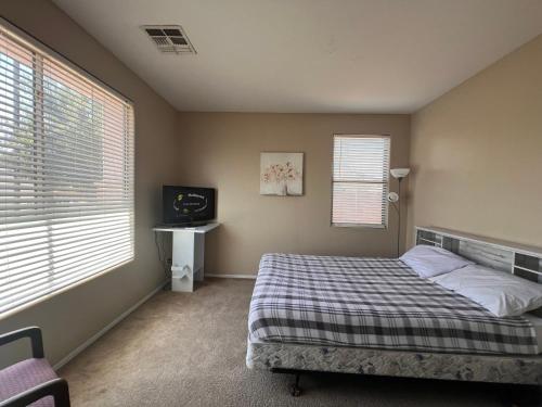 a bedroom with a bed and a television in it at Goodyear 2 Story Room 2 in Goodyear
