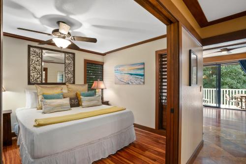 科洛阿Kauai Kiahuna Plantation #425 by Coldwell Banker Island Vacations的一间卧室，里面有一张床和一个吊扇