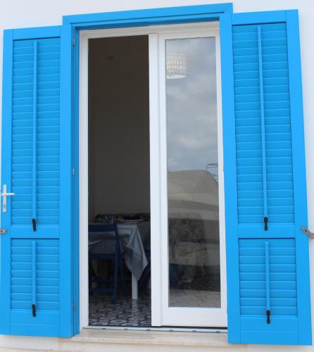 an open blue door with a table in the background at The twins Rooms in Marettimo 2 in Marettimo