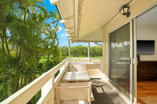 a balcony with white tables and chairs on it at Kauai Plantation Hale Suites E12 by Coldwell Banker Island Vacations in Kapaa