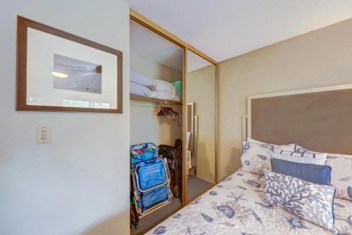 a bedroom with a bed and a mirror at Kauai Plantation Hale Suites C8 by Coldwell Banker Island Vacations in Kapaa