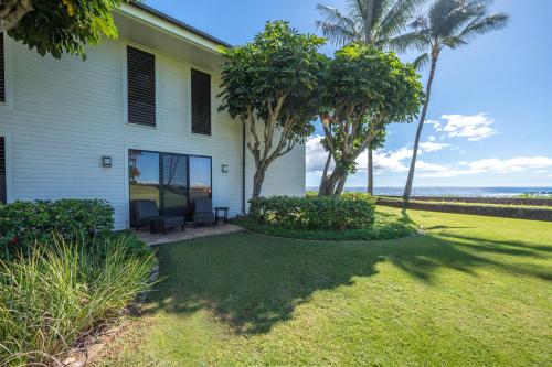 a house with palm trees in front of a yard at Kauai Poipu Kapili 51 by Coldwell Banker Island Vacations in Kipu