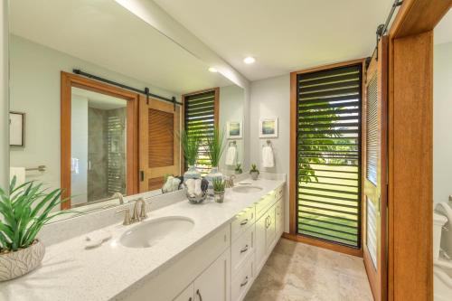a bathroom with two sinks and a large mirror at Kauai Poipu Kapili 51 by Coldwell Banker Island Vacations in Kipu