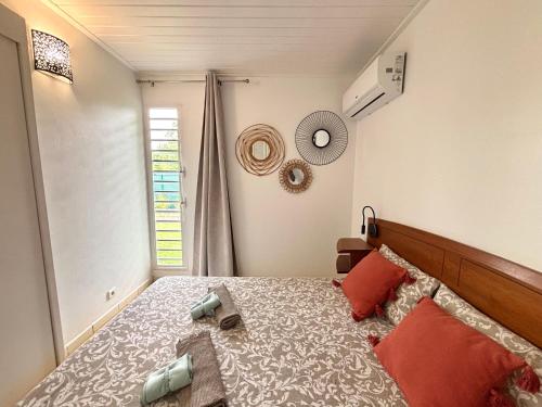 a bedroom with a large bed and a window at La Ruche de Maïa - Piscine - Jardin - Plage à 100m in Grand-Bourg