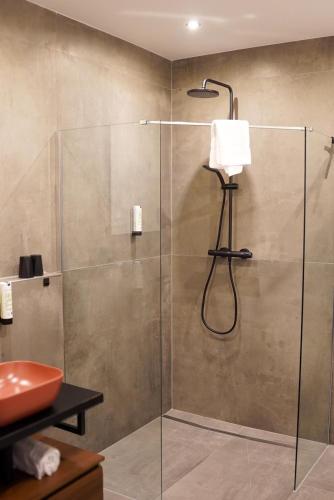 a bathroom with a glass shower with a sink at 7rooms - Self Check-in in Gütersloh