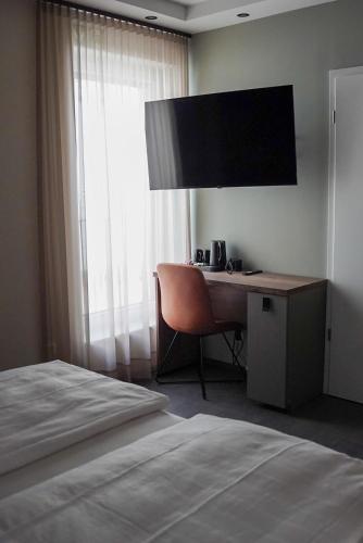 a hotel room with a desk and a bed at 7rooms - Self Check-in in Gütersloh