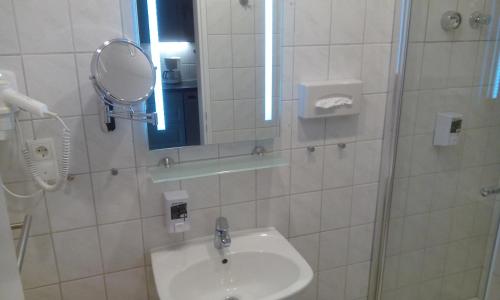 a bathroom with a sink and a mirror at DARZ GästeZimmer in Hamburg